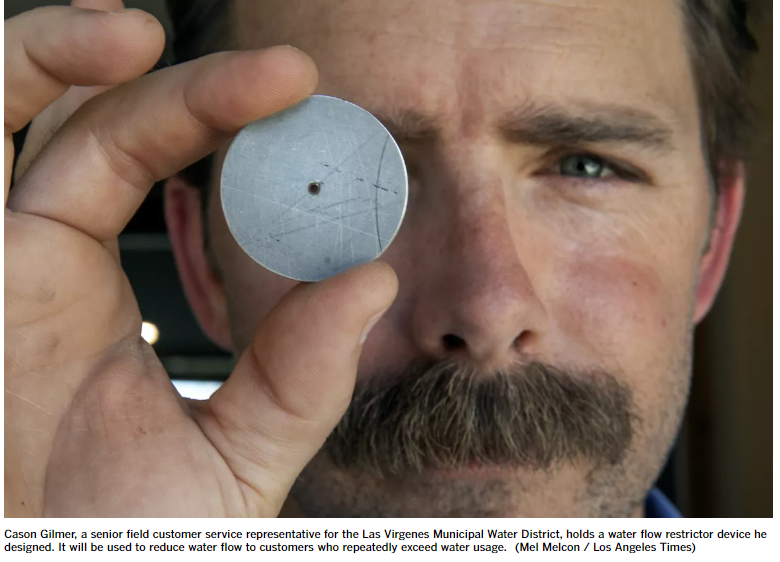 A person holds a small, circular water flow restrictor device close to the camera.