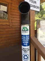 Fishing line recycling bin with a sign encouraging waterway cleanliness and wildlife safety.
