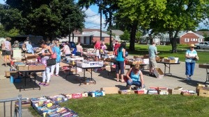 May contain: accessories, bag, handbag, grass, plant, person, people, desk, furniture, table, car, transportation, and vehicle