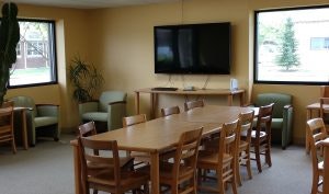 May contain: architecture, building, dining room, dining table, furniture, indoors, room, table, computer hardware, electronics, hardware, monitor, screen, tv, and chair