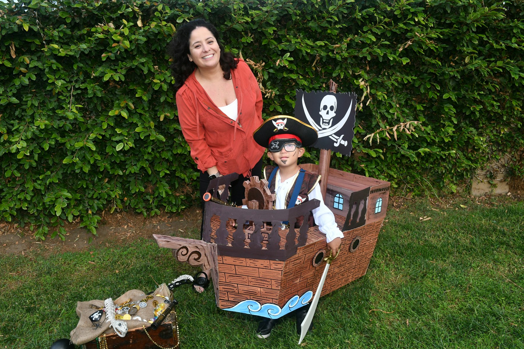 Parent with her son that is dressed in a pirate costume