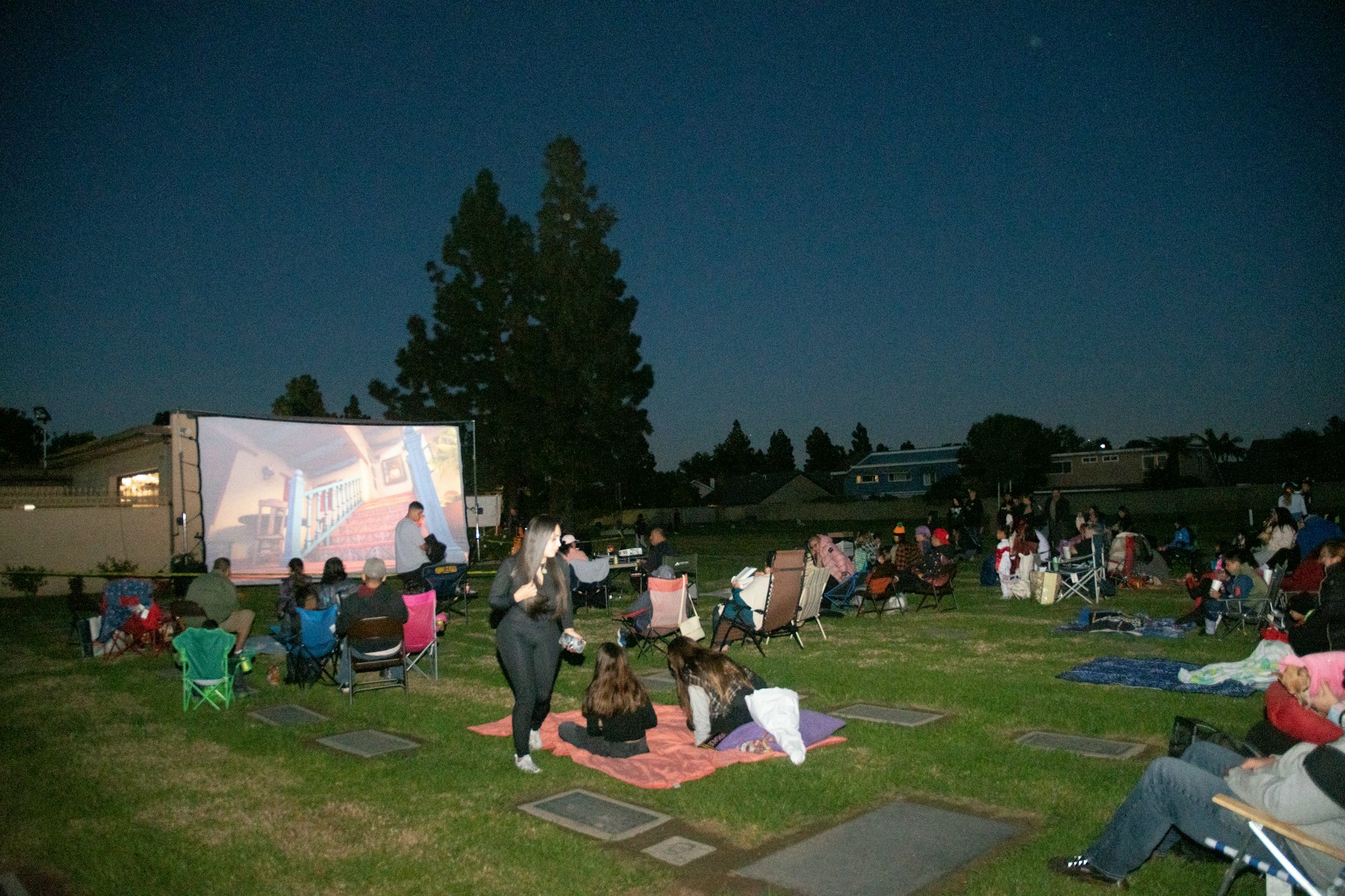 May contain: park, shelter, grass, outdoors, nature, plant, building, architecture, people, person, grove, tree, vegetation, woodland, land, lawn, concert, crowd, backyard, yard, chair, furniture, shoe, footwear, clothing, and summer