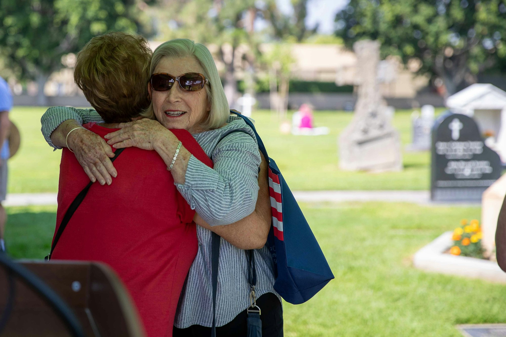 May contain: grass, plant, face, head, person, photography, portrait, people, adult, female, woman, hugging, and tomb