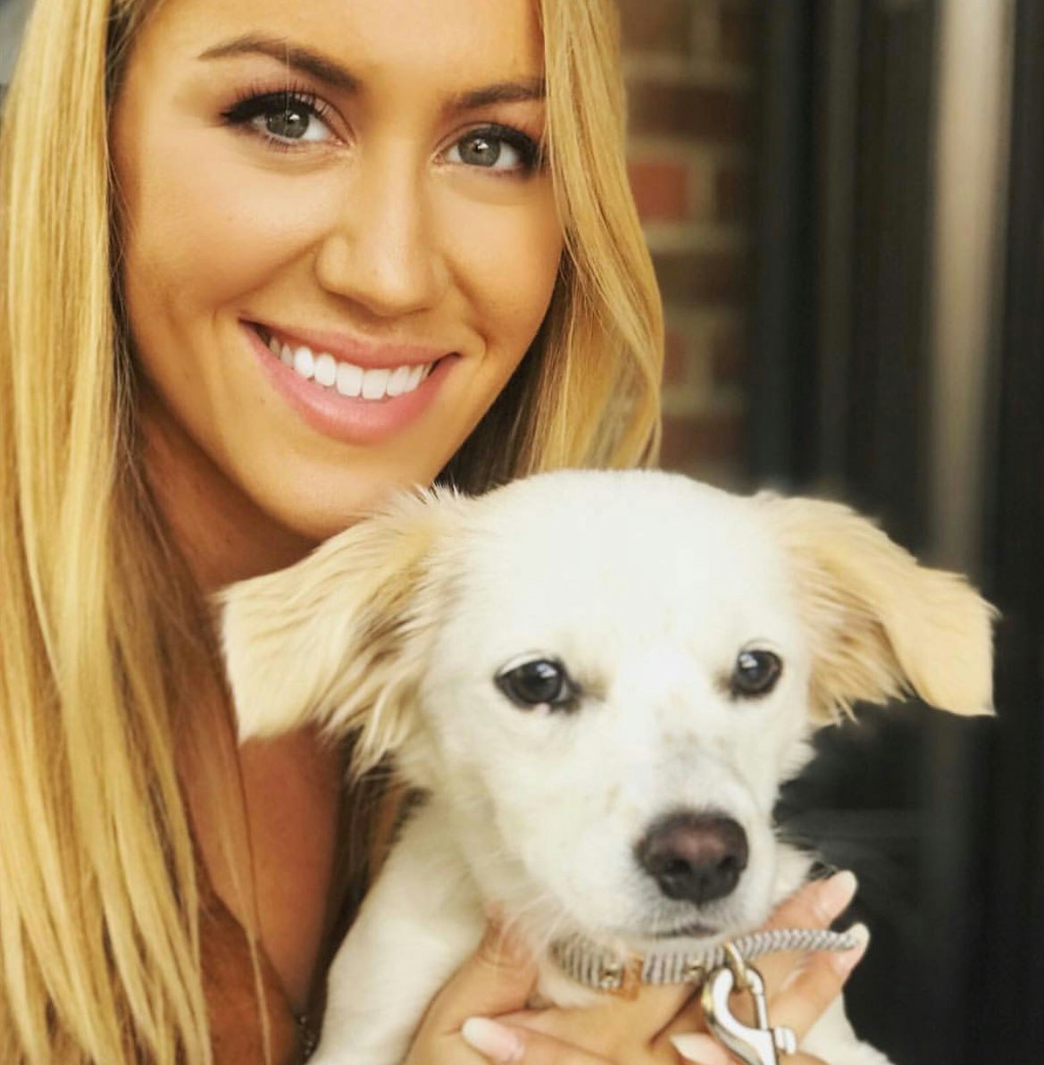 Young Caucasian woman holding up her dog