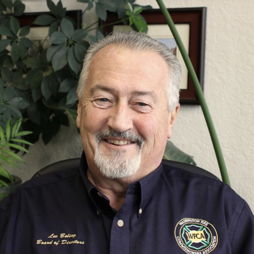 Smiling white male with graying hair and beard. wearing a dark blue buttoned shirt with name and WFCA logo.