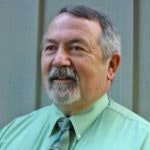 Bill Eckroff in a sea green button-down shirt with green patterned tie