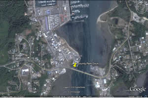 The image shows a satellite view of a waterfront area, including docks, marinas, and nearby land development.