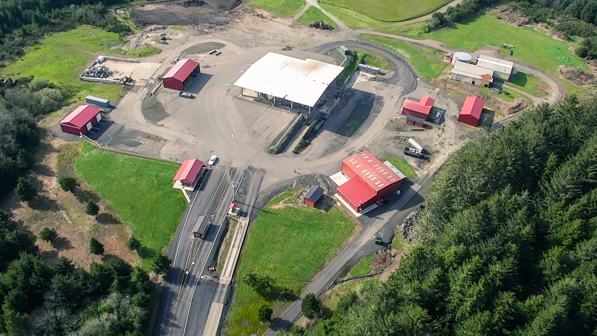 An aerial view of a facility with several buildings, roads, and greenery surrounding it, possibly for industrial or storage use.