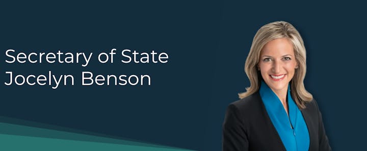 Image of a smiling woman in a suit labeled "Secretary of State Jocelyn Benson" on a dark background.