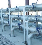 The image shows a series of industrial pipes with blue valves, likely for fluid transportation in a facility.