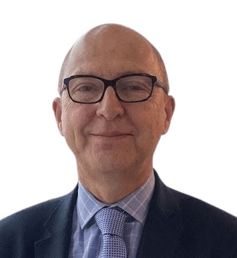 The image shows a professional man with glasses, wearing a suit and tie, smiling against a plain background.
