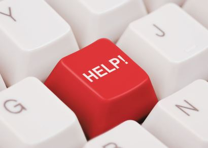 A close-up of a red keyboard key labeled "HELP!" among white keys, highlighting urgency or assistance.