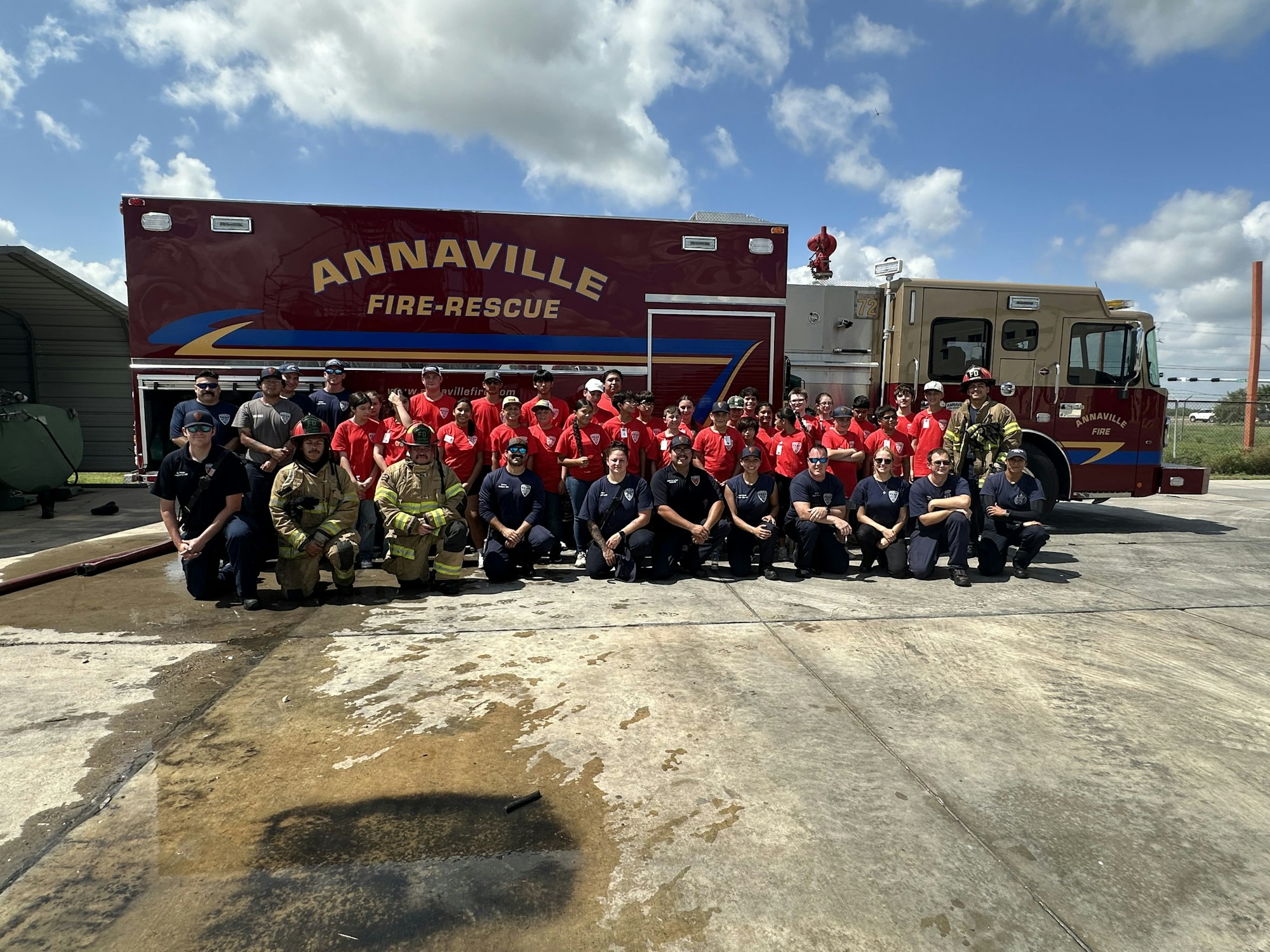 A group of people posing in front of an Annaville fire-rescue truck with firefighters in uniform.