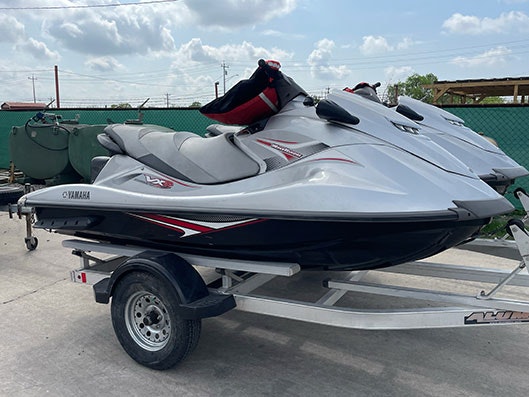 A Yamaha VX jet ski on a trailer, parked outdoors under a cloudy sky.