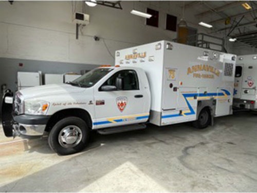 A white emergency vehicle with the label "ANNAWAN FIRE" is parked inside a garage.