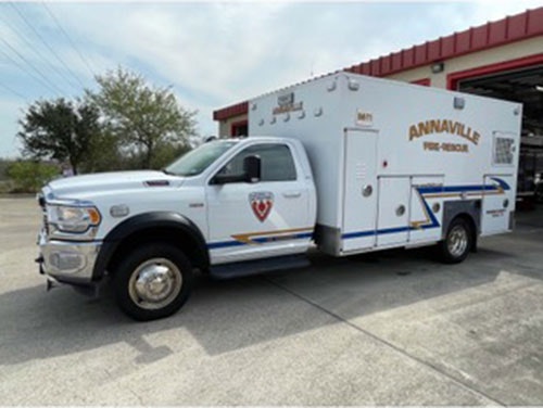 A white Annaville Fire-Rescue truck parked outside a building.