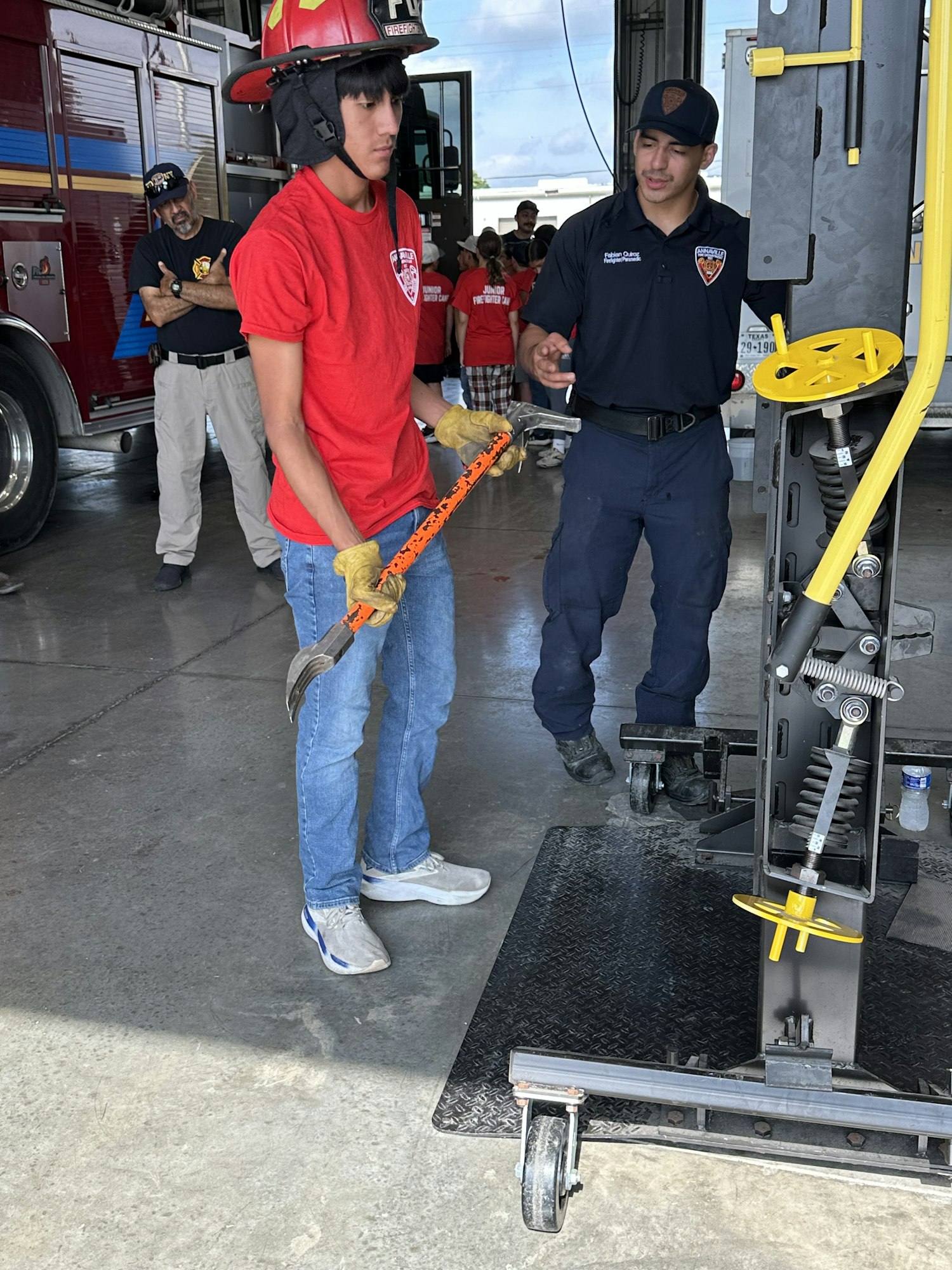 Two people in a fire station are using firefighting equipment during a training exercise.
