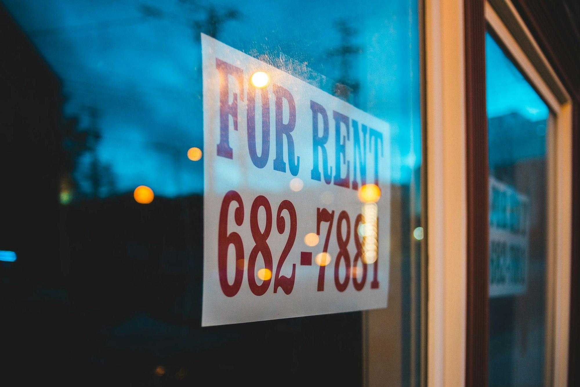 "For Rent" sign placed on a window displays contact number 682-7881.