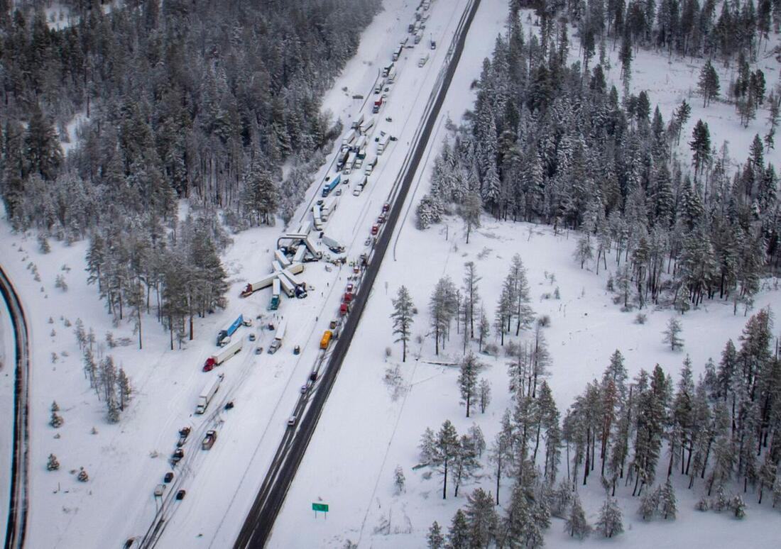 Aerial view of a vehicle pileup on a busy snowy road