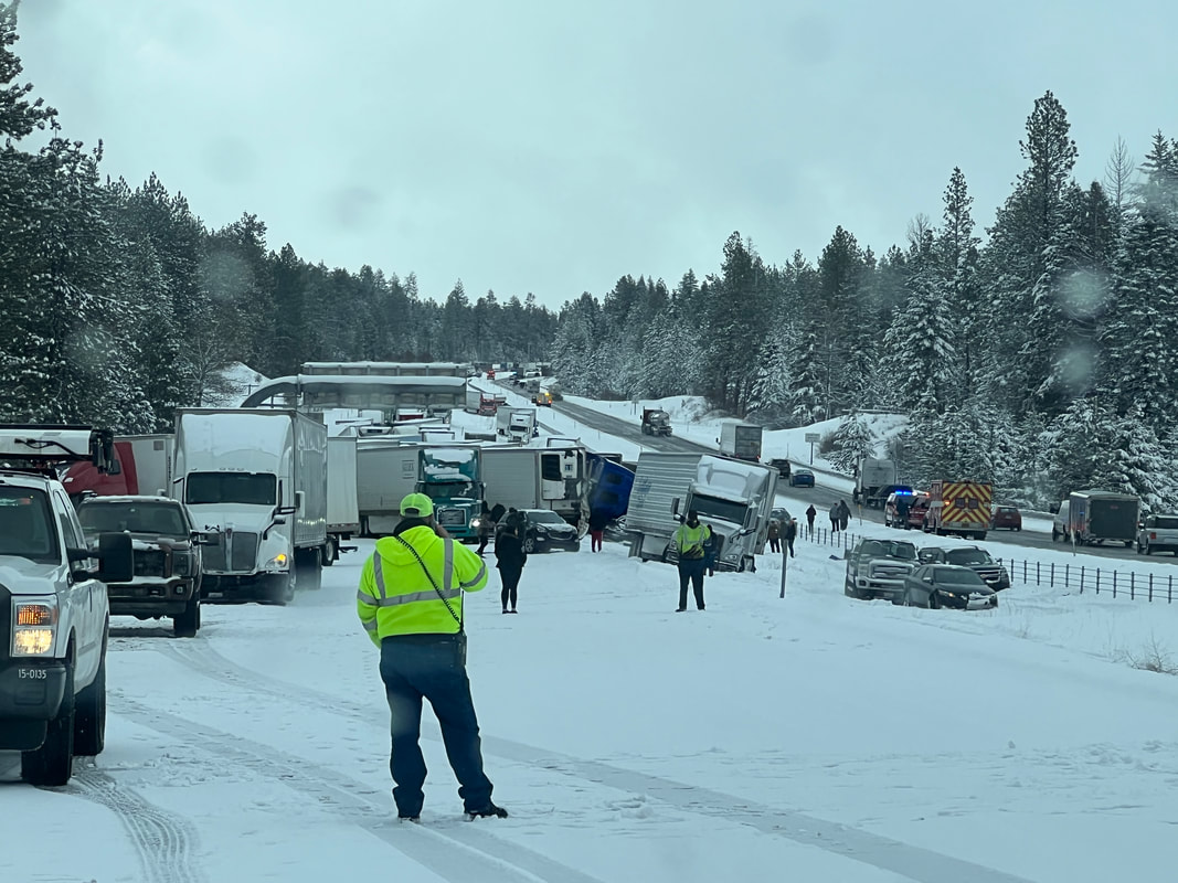 Photo of workers assisting vehicles in a pile up