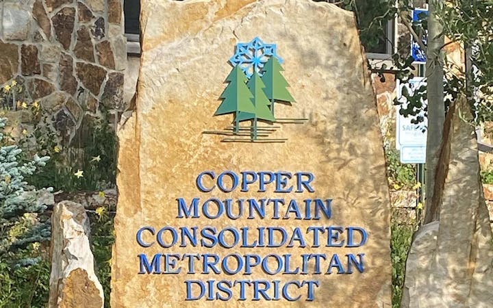 Sign for "Copper Mountain Consolidated Metropolitan District" with a pine tree and snowflake logo.