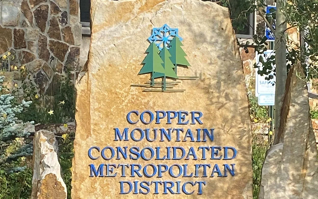 Sign for "Copper Mountain Consolidated Metropolitan District" with a pine tree and snowflake logo.