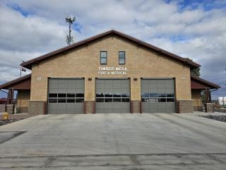 Brick fire station with three garage doors and "Timber Mesa Fire & Medical" signage.