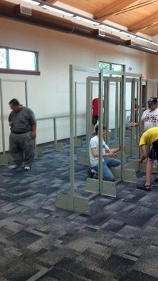 People using metal detectors at an event or facility entrance.