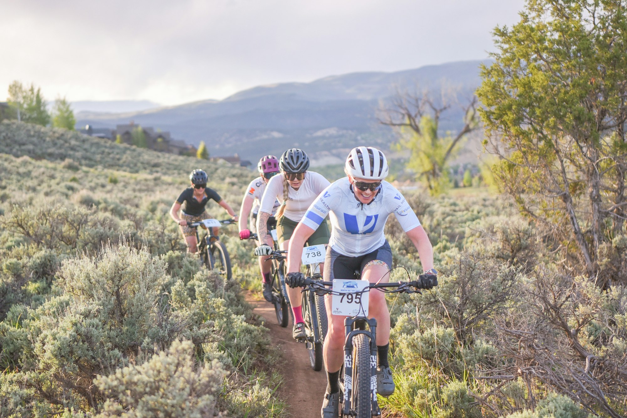 A group of mountain bikers racing on a trail in the Eagle Ranch Classic
