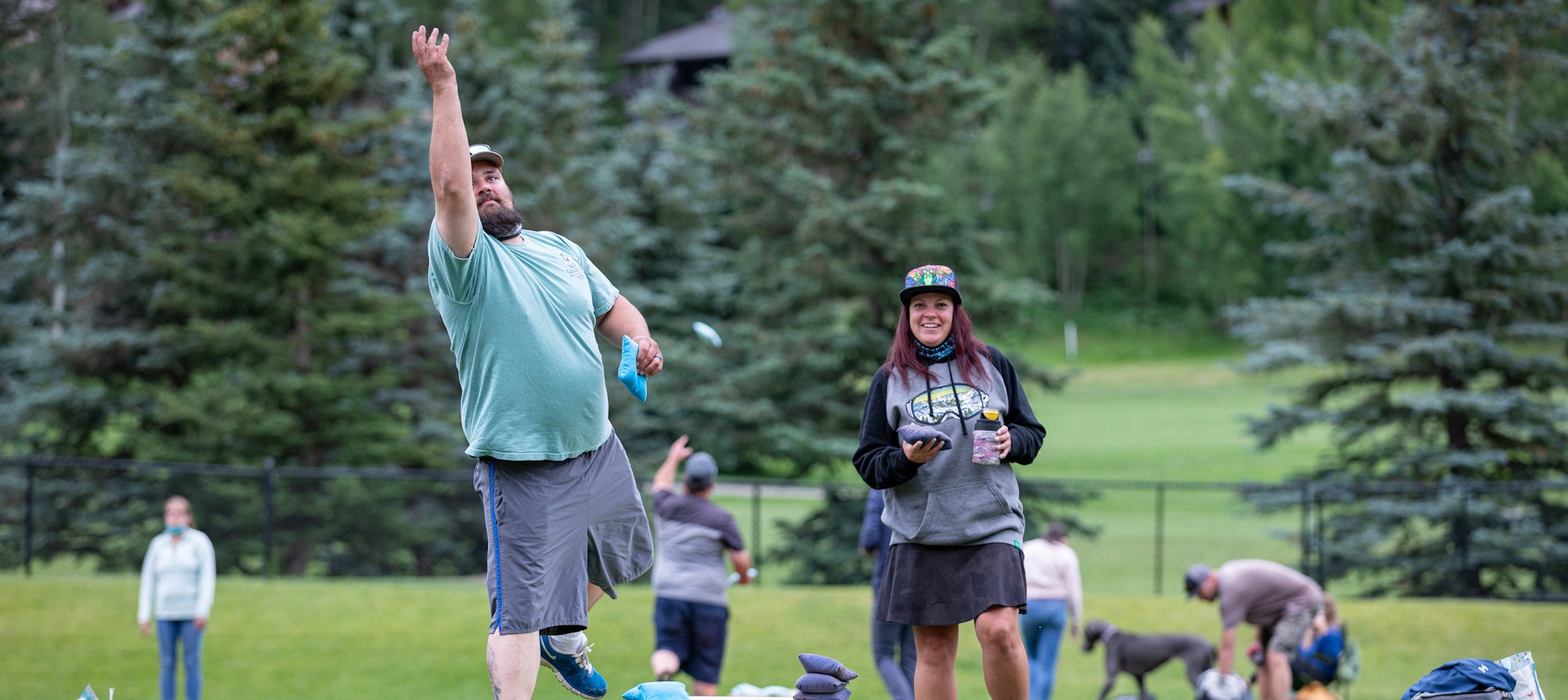 A man throwing a frisbee with people in a park.