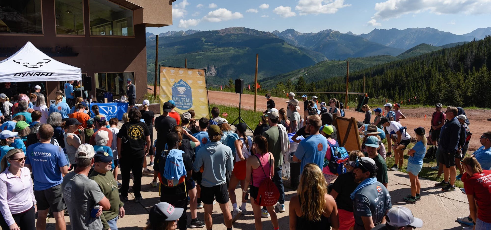 Crowd gathered at a mountain event with clear skies and scenic views.