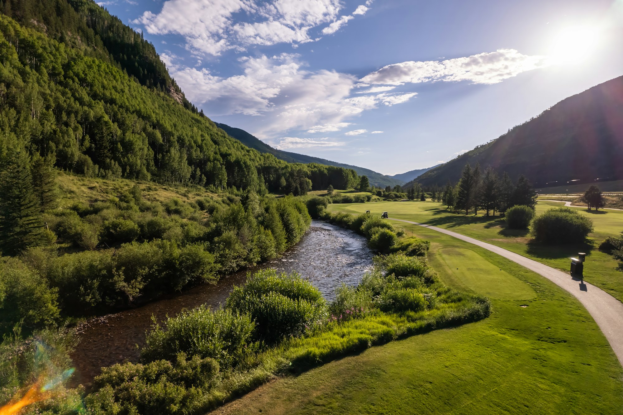 The Vail Golf Course with a winding path, trees, and mountains.