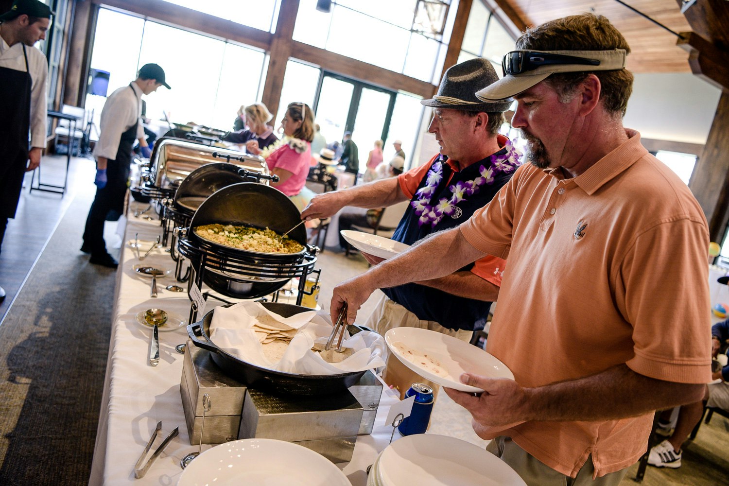 People serving themselves food from a buffet.