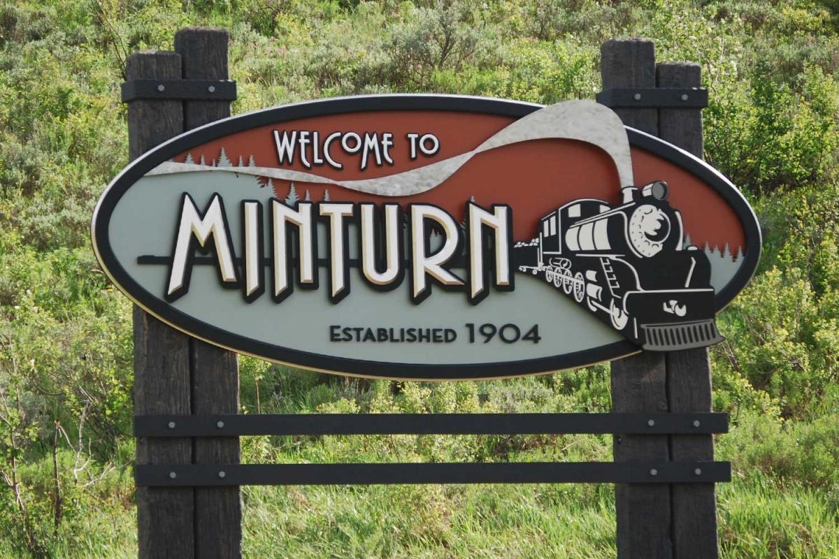 Sign reading "Welcome to Minturn, Established 1904" with a train illustration.