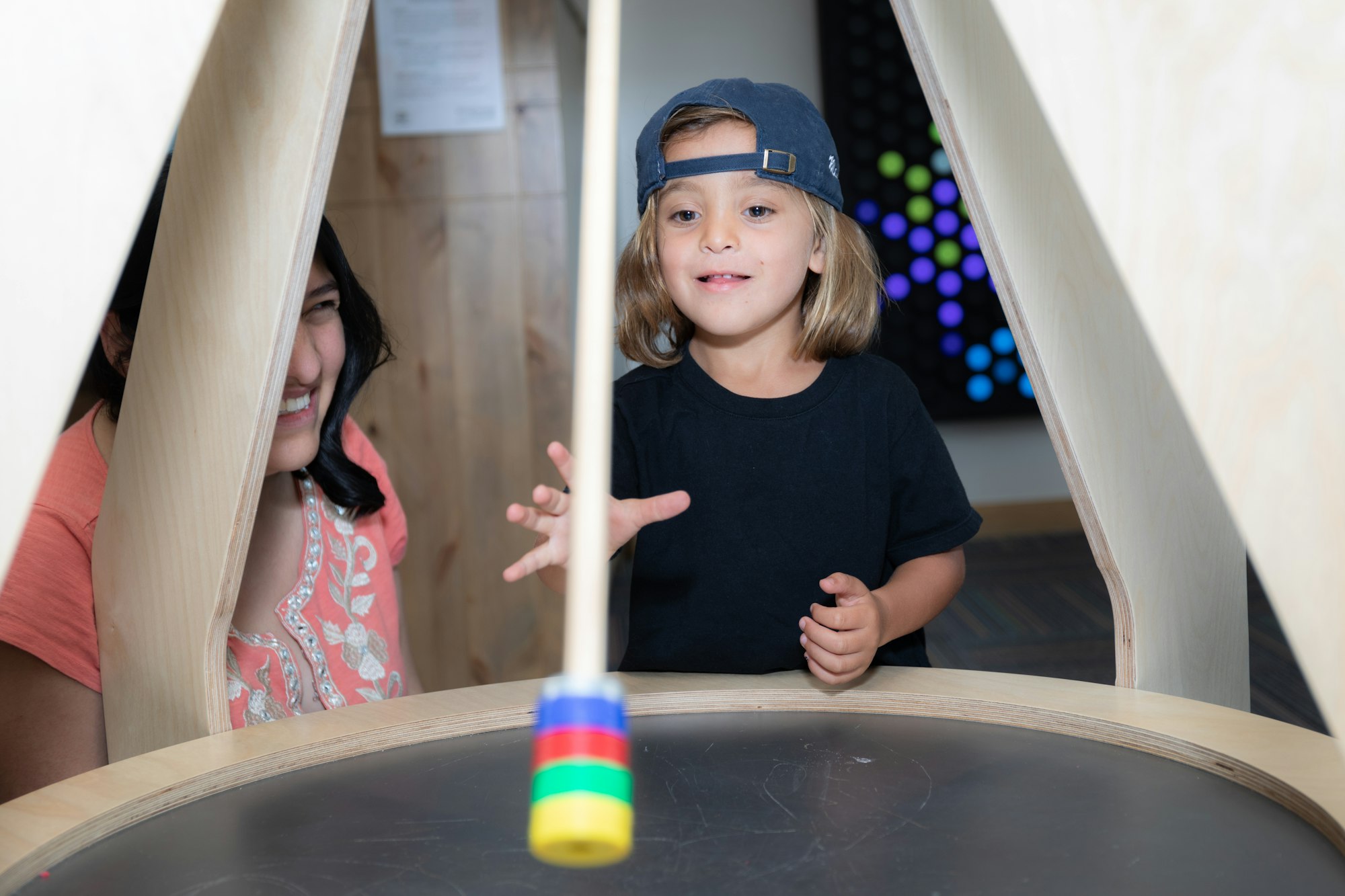 Two people playing with a floating, spinning toy in an indoor setting.