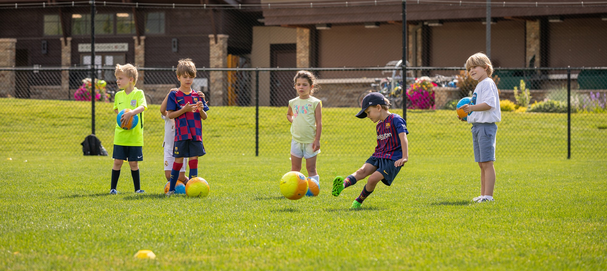 Children at soccer practice on a sunny day.