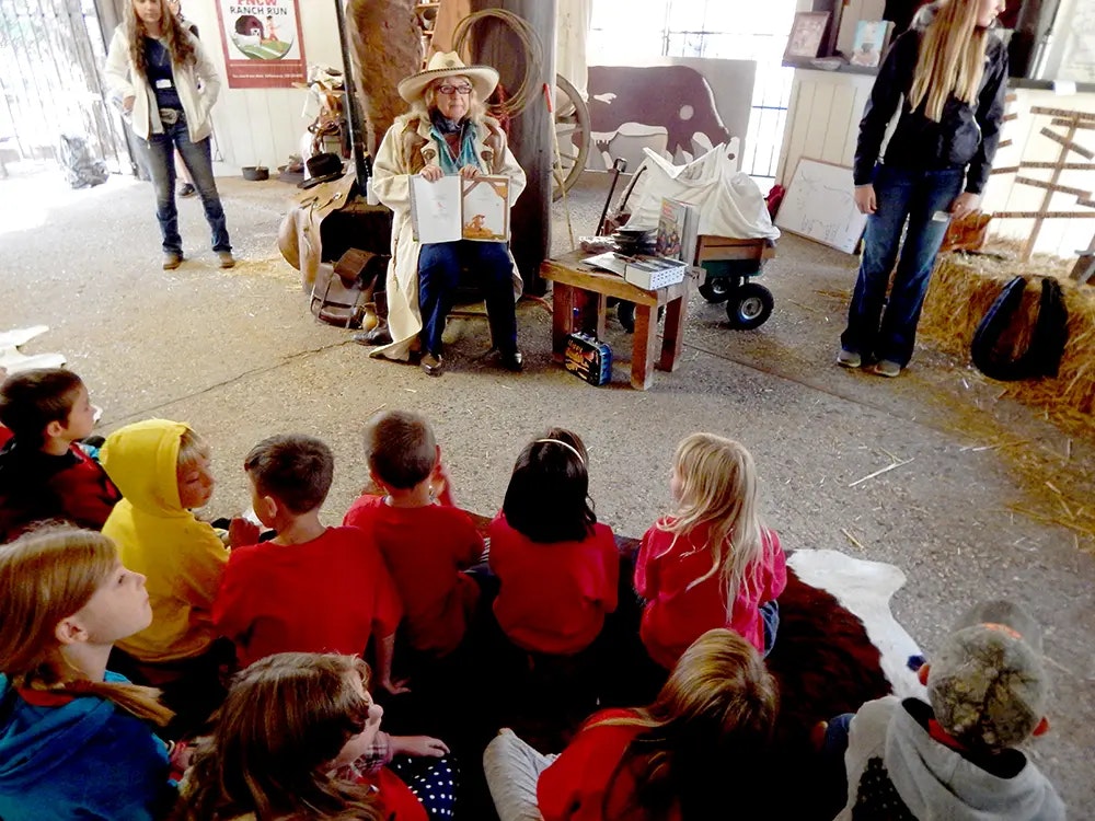 children sitting, listening to woman