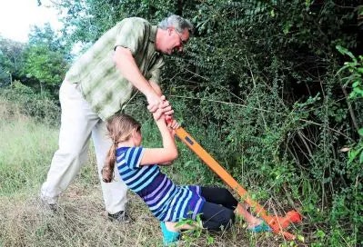 man and child using a tool in the ground