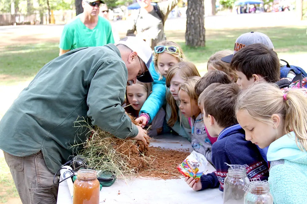 children gathered, listening to man