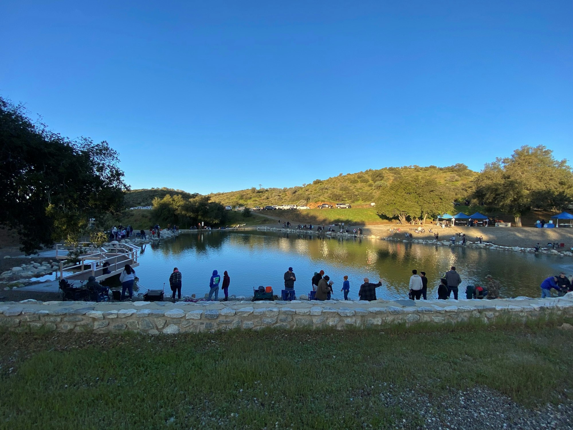 May contain: nature, outdoors, scenery, pond, water, lake, person, tent, waterfront, clothing, and hat