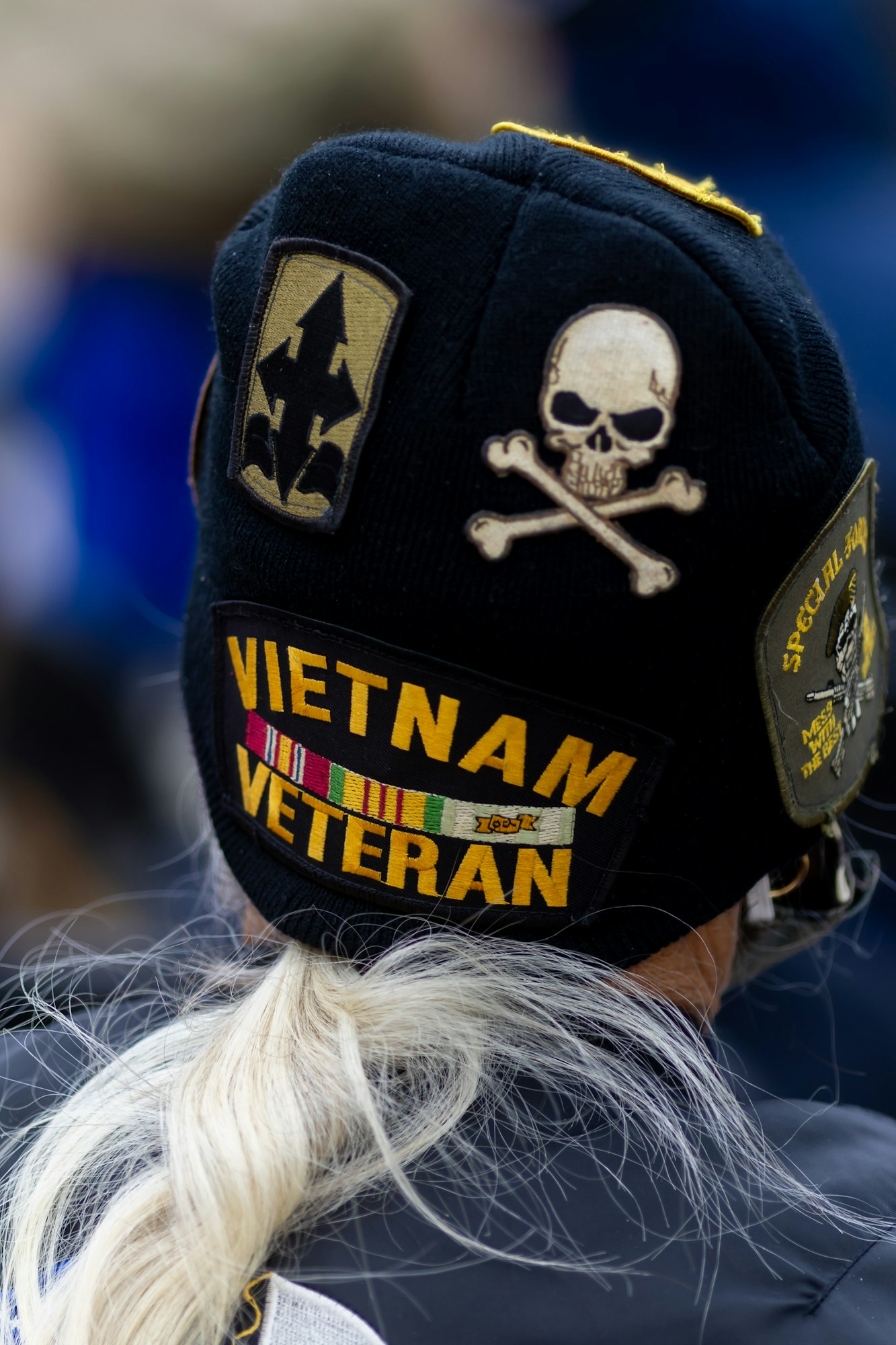 A Vietnam veteran's cap with military patches and insignia, including a skull and crossbones.