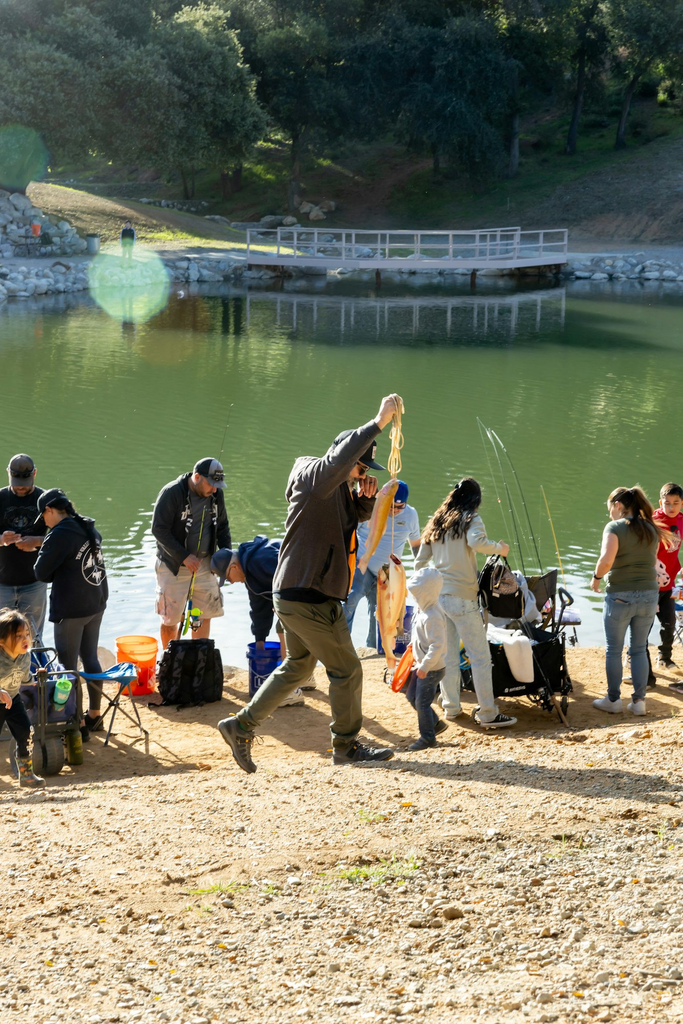 May contain: fishing, leisure activities, outdoors, water, clothing, footwear, shoe, adult, female, person, woman, male, man, accessories, bag, handbag, angler, glasses, hat, pants, wristwatch, and shorts