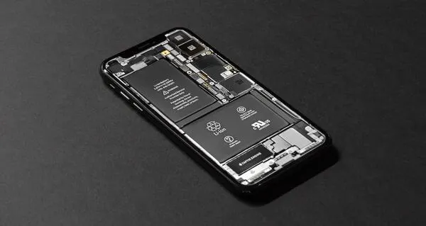 A smartphone with its internal components visible on a dark surface.