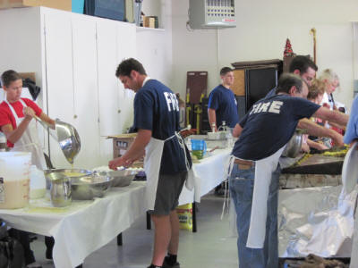 Firefighters preparing food in a community kitchen.