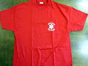 A red T-shirt with a white logo on the front lying flat on a green surface.
