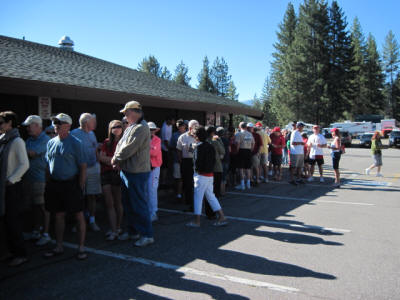 People queued outside a building under clear skies.