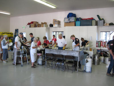 A group of people working together in what looks like a community kitchen or food prep area.