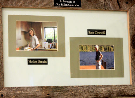A memorial frame with two photos and names: Helen Strain and Steve Churchill, titled "In Memory of Our Fallen Comrades."