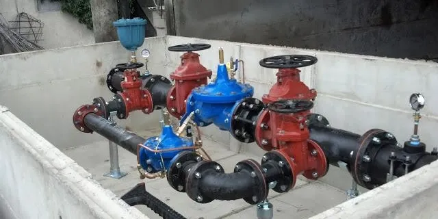 Industrial valves and pipes in a concrete setting.