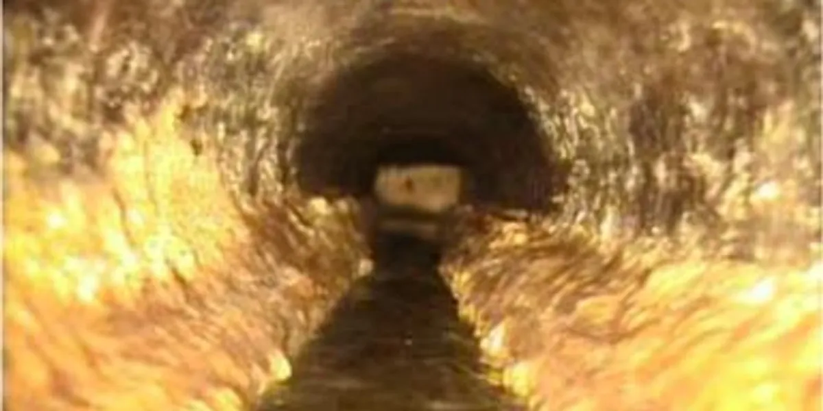 A blurry image showing a tunnel-like structure with a figure at the far end that looks humanoid.